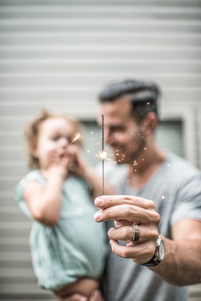 father and daughter with sparkler style firework
